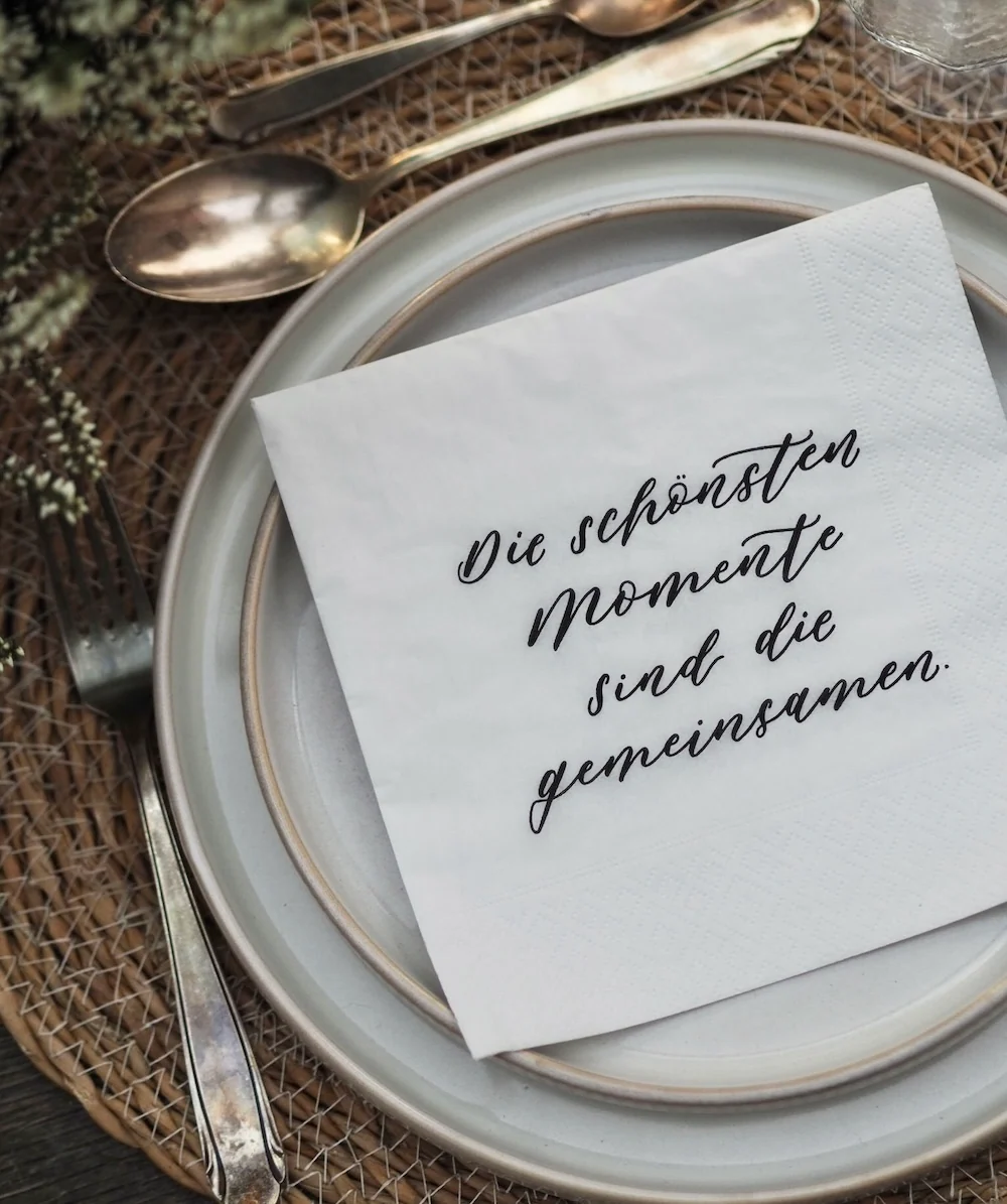 Servietten Gemeinsame Momente mit dezenter Schriftgestaltung auf gedecktem Tisch